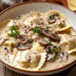 Italian Winter Dish Of Ravioli In A Creamy Mushroom Sauce, Garnished With Herbs And Pepper, Perfect For Promoting Hearty And Comforting Seasonal Recipes.