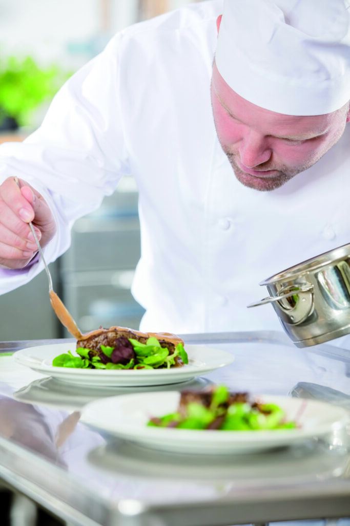 Professional Chef Prepare Meat Dish At Restaurant